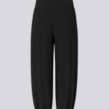 Balloon pants in black with a relaxed fit, made from 100% recycled polyester. Tullemd pants have an invisible side zipper, side pockets, and elastic at the leg hems.