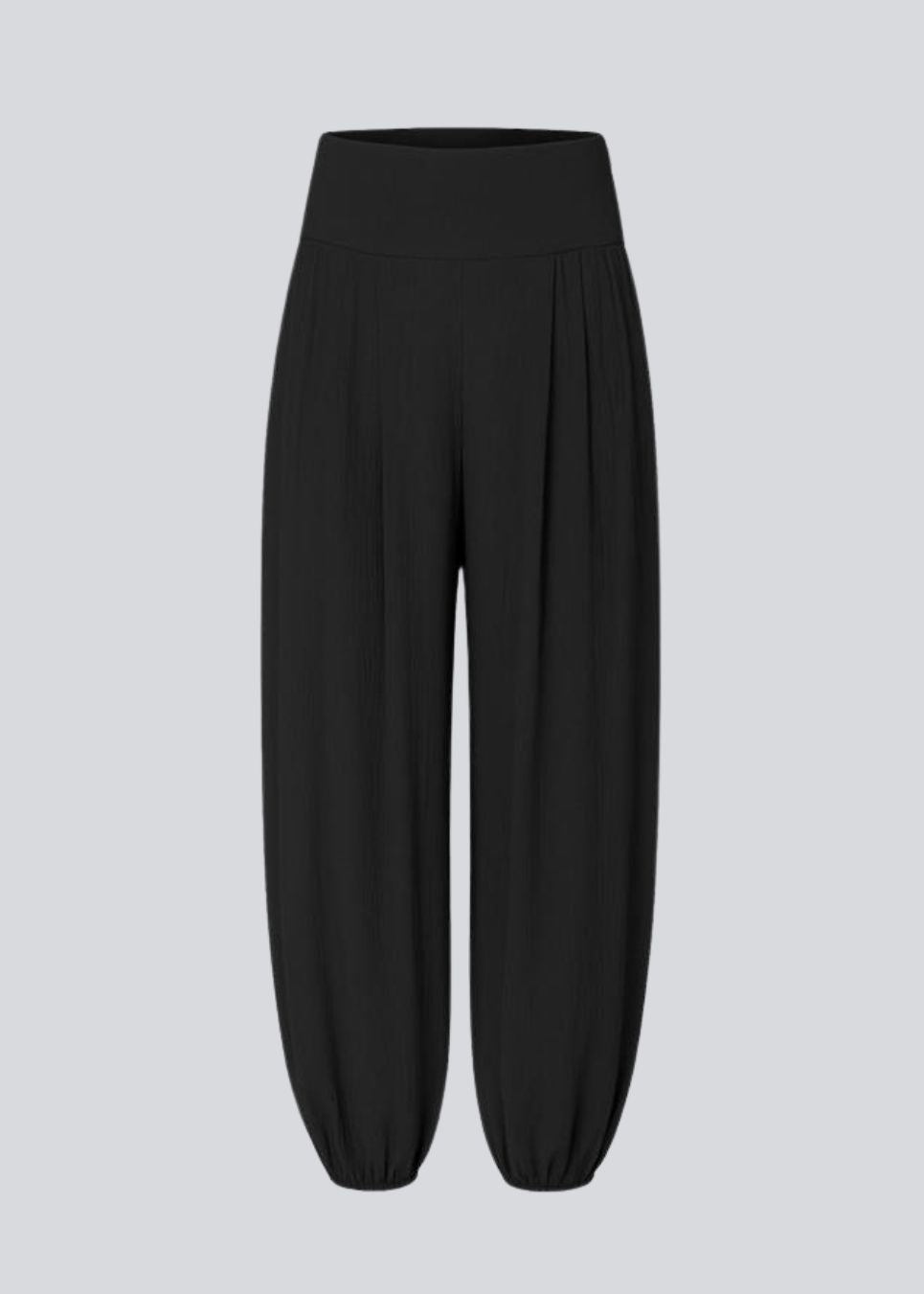 Balloon pants in black with a relaxed fit, made from 100% recycled polyester. Tullemd pants have an invisible side zipper, side pockets, and elastic at the leg hems.