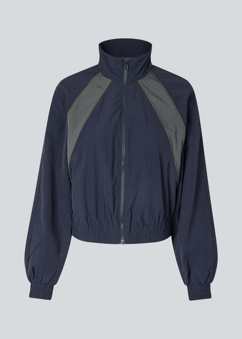 Dark blue tracksuit jacket in 100% recycled nylon. Volmermd jacket has contrast panels, a high neck and a zipperclosure in front.&nbsp;
