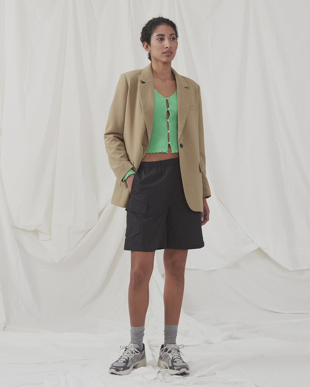 Slim fitted, slightly cropped cardigan in green with buttons at the front. DorisMD cardigan has a deep and round neckline, long sleeves, and lettuce hems. The model is 177 cm and wears a size S/36.