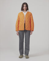 Lightly padded jacket in orange made from recycled nylon with quilted seams. CappelMD jacket has a relaxed shape detailed with a v-neck, long sleeves, and push buttons in front.
