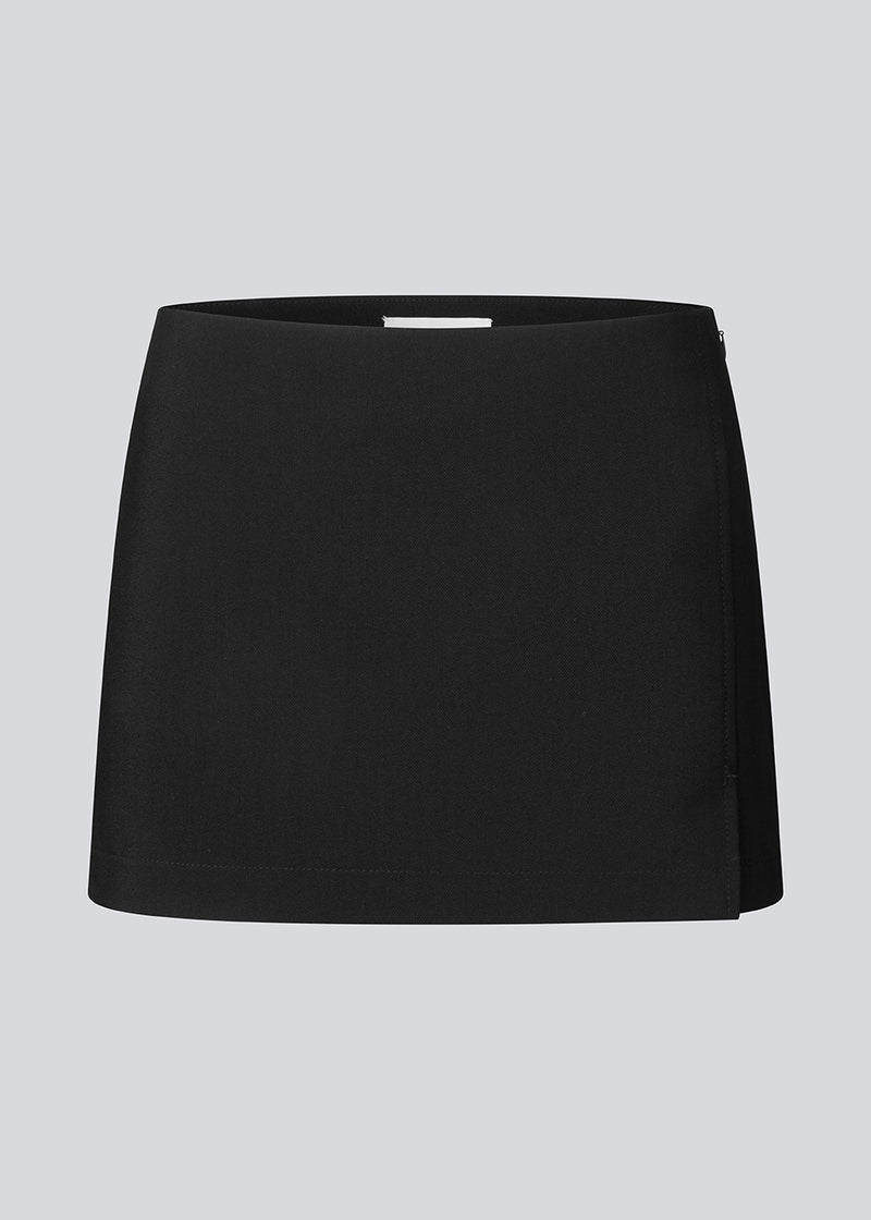 Mini skirt with a medium low waist. JosefineMD skirt has a slim fit with a drap detail along with a small slit and zipper at one side. The model is 177 cm and wears a size S/36.