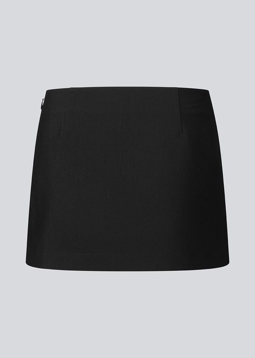 Mini skirt with a medium low waist. JosefineMD skirt has a slim fit with a drap detail along with a small slit and zipper at one side. The model is 177 cm and wears a size S/36.