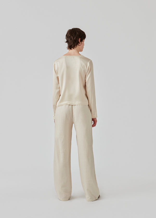 Long pants in beige with a relaxed fit and long wide legs and an elasticated waist for extra comfort. TulsiMD pants are made from a soft mix of linen and rayon.  The model is 177 cm and wears a size S/36.