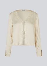 TulaMD shirt in an EcoVero viscose. The shirt is designed with a v-shape at the neckline, opening in front with tie, and long sleeves with a slit. 