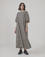 Long dress with a wide skirt and voluminous puff sleeves. CoraMD print dress has a round neck with a cut out and bow in the back. Made from organic cotton.  The model is 174 cm and wears a size S/36.