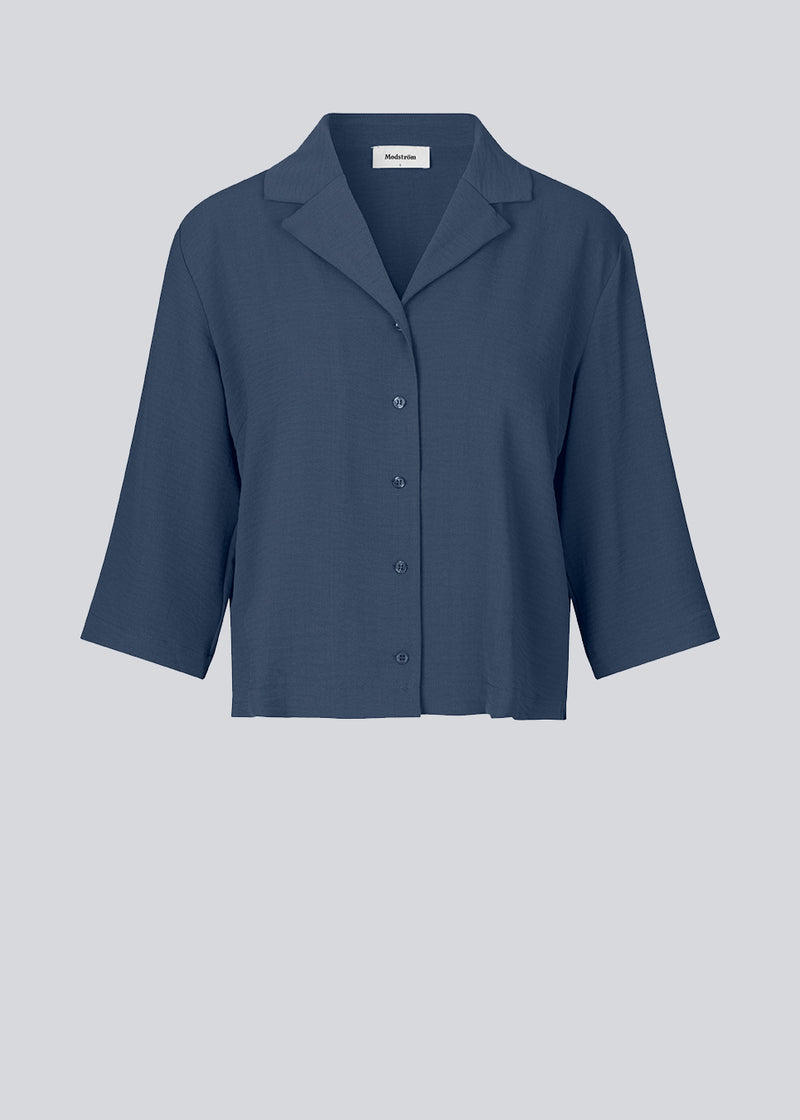 Shirt in dark blue in a relaxed silhouette and 3/4 length sleeves. AaliyahMD shirt has a resort collar, dropped shoulders and button closure in front.