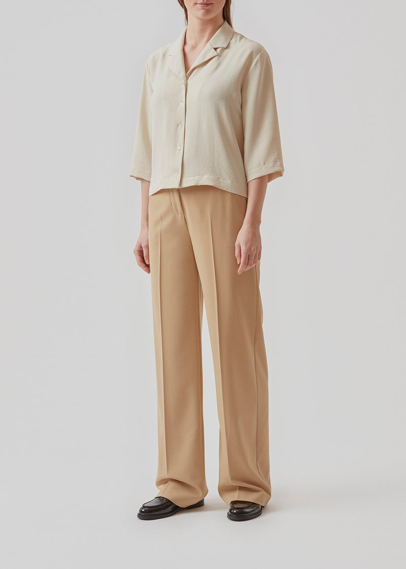 Shirt in beige in a relaxed silhouette and 3/4 length sleeves. AaliyahMD shirt has a resort collar, dropped shoulders and button closure in front.  Material: 100% Polyester