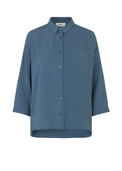 Beautiful shirt in dark blue in a classic design. Alexis shirt has a collar and is closed at the front by buttons. The shirt has 3/4 length sleeves and a chest pocket, which adds details. The model is 174 cm and wears a size S/36