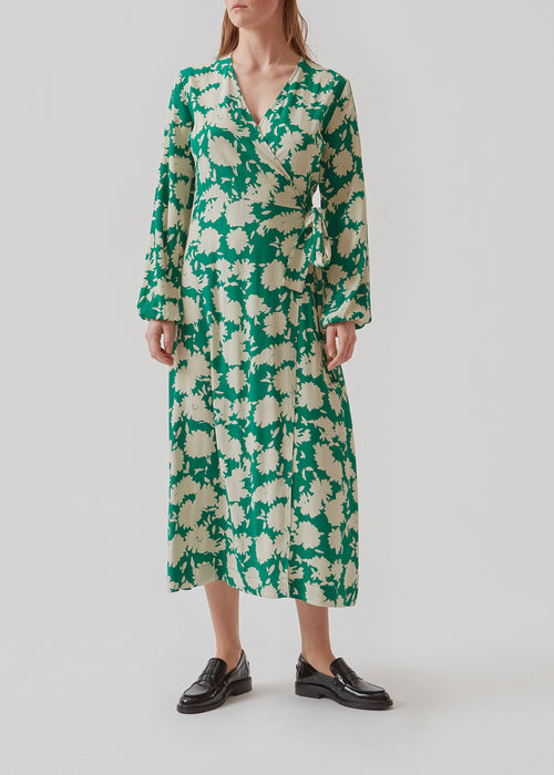 Long-sleeved dress in a green print with a v-neckline and wrap-effect with tiebelt at the waist. The skirt of AllisonMD print dress cuts at ankle length. The material is an EcoVero viscose quality.