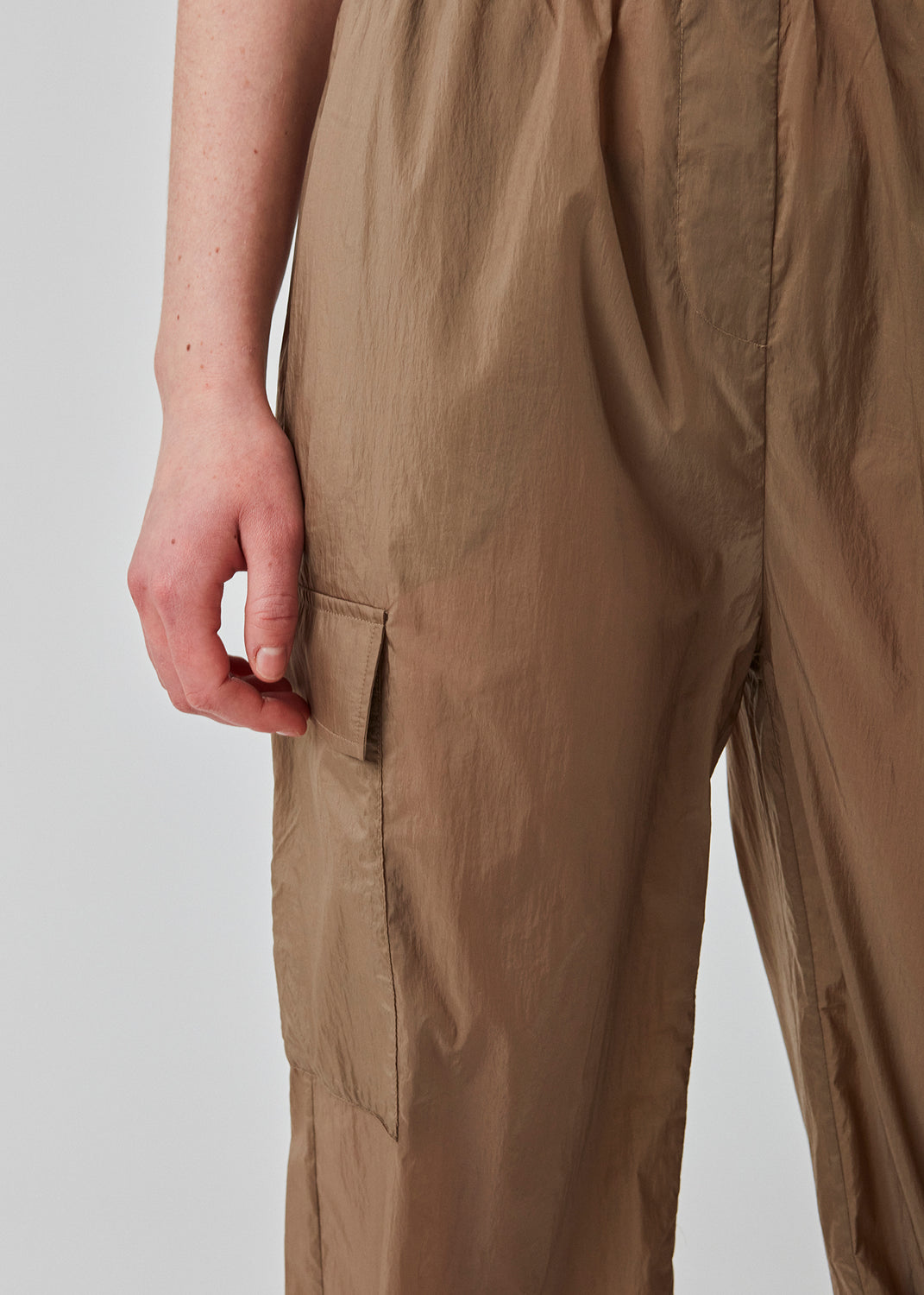 Pants in recycled nylon in the color Dune. AmayaMD pants have a high waist and straight legs with adjustable drawstring at hem. Covered elasticated waist and two large pockets on the legs.