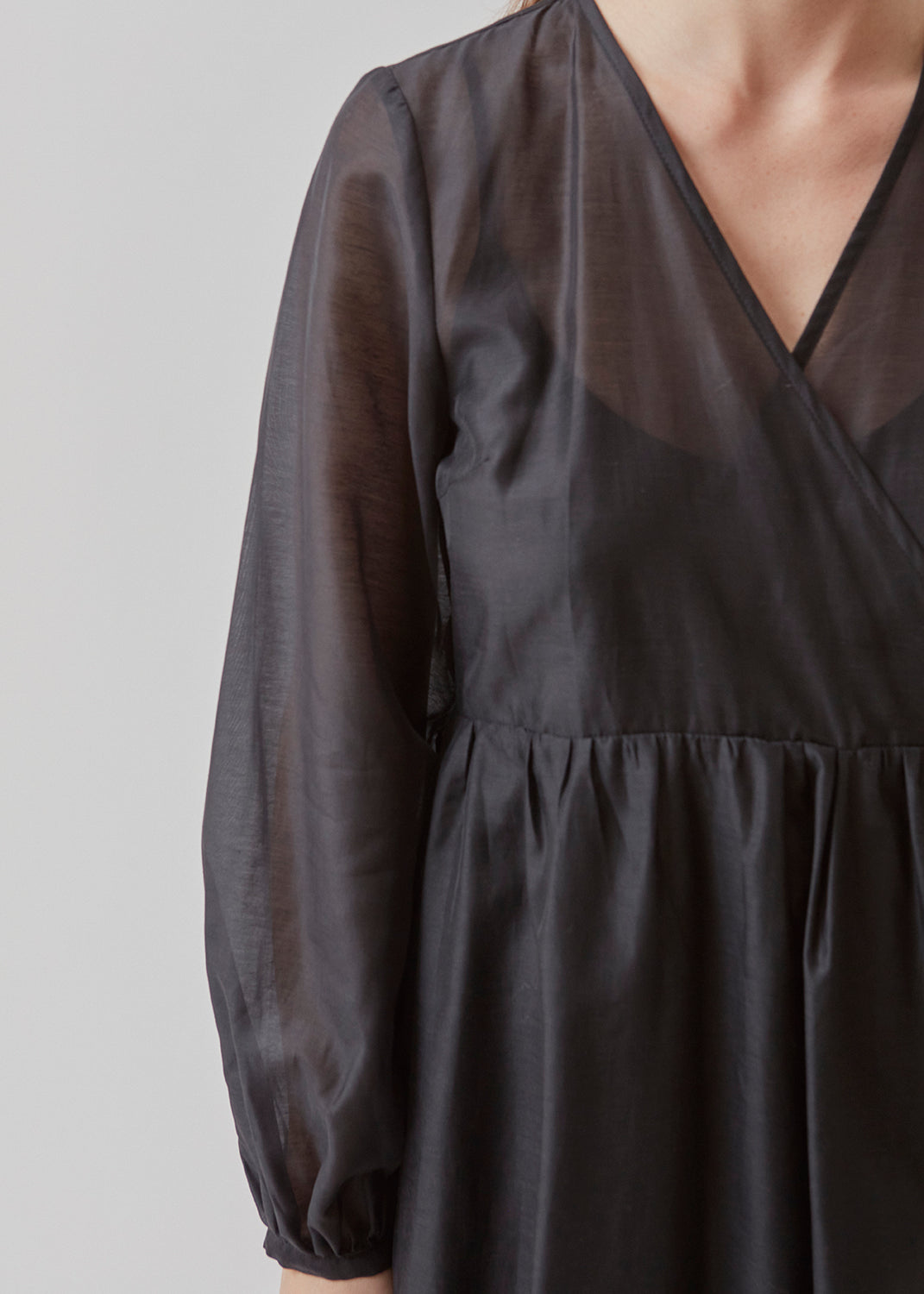 Midi dress in an airy linen quality that is slightly see-through. AmoraMD dress has long balloon sleeves, v-neckline and wrap-effect with tiebelt. Slip dress is included.