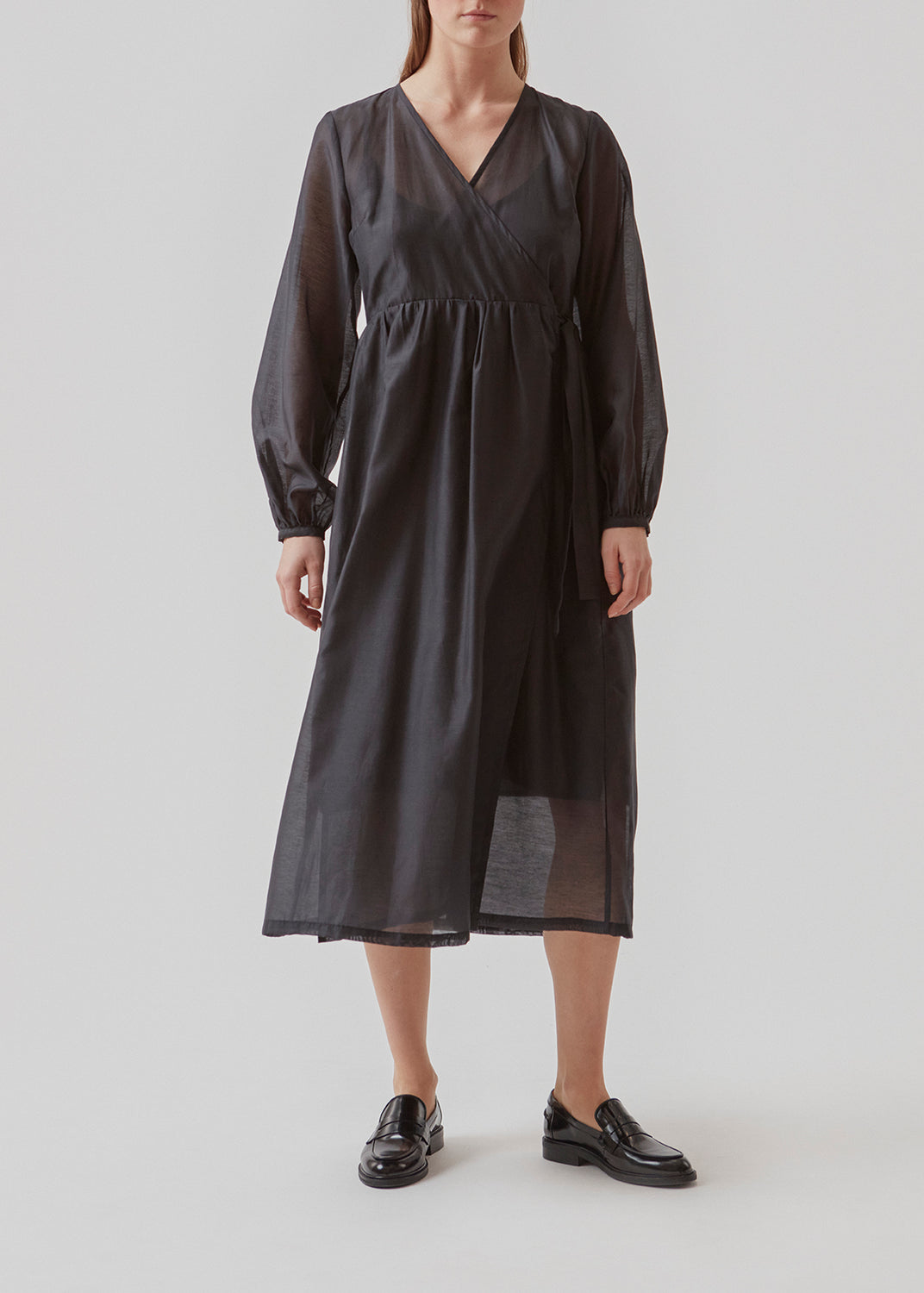 Midi dress in an airy linen quality that is slightly see-through. AmoraMD dress has long balloon sleeves, v-neckline and wrap-effect with tiebelt. Slip dress is included.