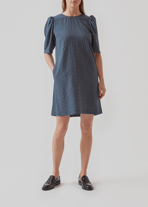 Short dress with an easy-fitting silhouette. AndreaMD dress has short sleeves with volume and an opening in the back with a button clos
