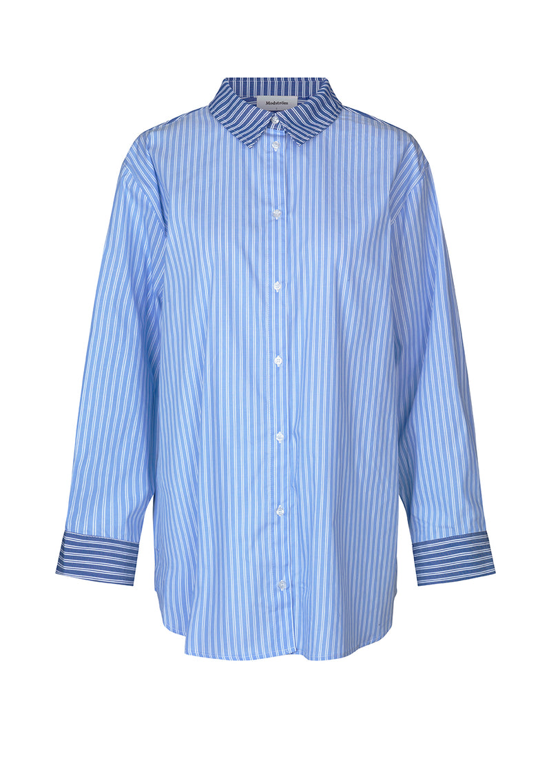Voluminous shirt in the color blue stripe in a cotton poplin with contrasting stripes. AndyMD shirt has dropped shoulders and wide sleeves. Doublelayered yoke with pleat at the back.
