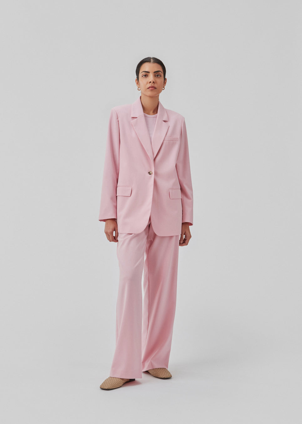 Oversized blazer in dusty sorbet with a drapey fit. AnkerMD blazer has collar and notch lapels with a single button closure. Flap welt front pockets. Slits on cuffs and single back vent. Lined.  The model is 177 cm and wears a size S/36.