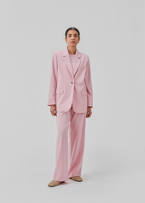 Oversized blazer in dusty sorbet with a drapey fit. AnkerMD blazer has collar and notch lapels with a single button closure. Flap welt front pockets. Slits on cuffs and single back vent. Lined.  The model is 177 cm and wears a size S/36.