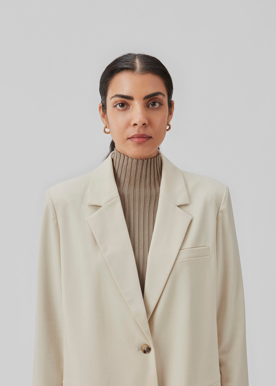 Oversized blazer in beige with a drapy fit. AnkerMD blazer has collar and notch lapels with a single button closure. Flap welt front pockets. Slits on cuffs and single back vent. Lined.  The model is 177 cm and wears a size S/36.  Shop matching shorts: AnkerMD shorts or bukser: AnkerMD pants.