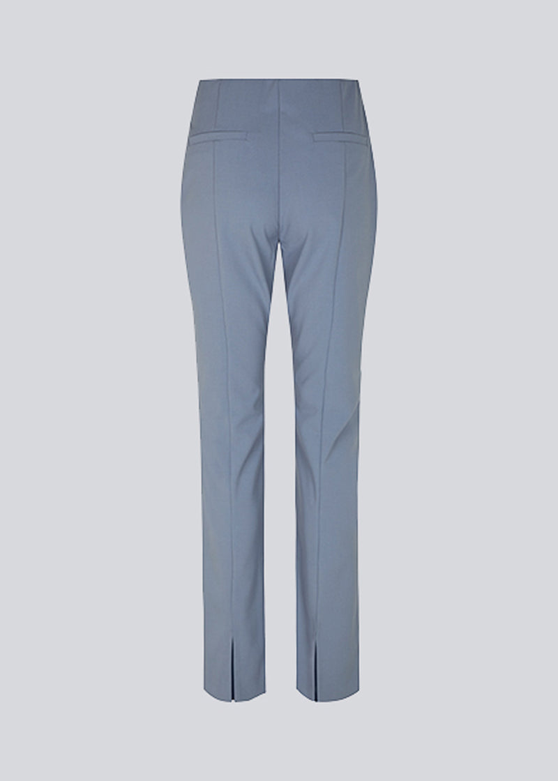 Pants in the color Dusk in a slim silhouette with hidden closure at one side. AnkerMD slit pants have decorative paspel back pockets, sewn-in creases and slits at hems.