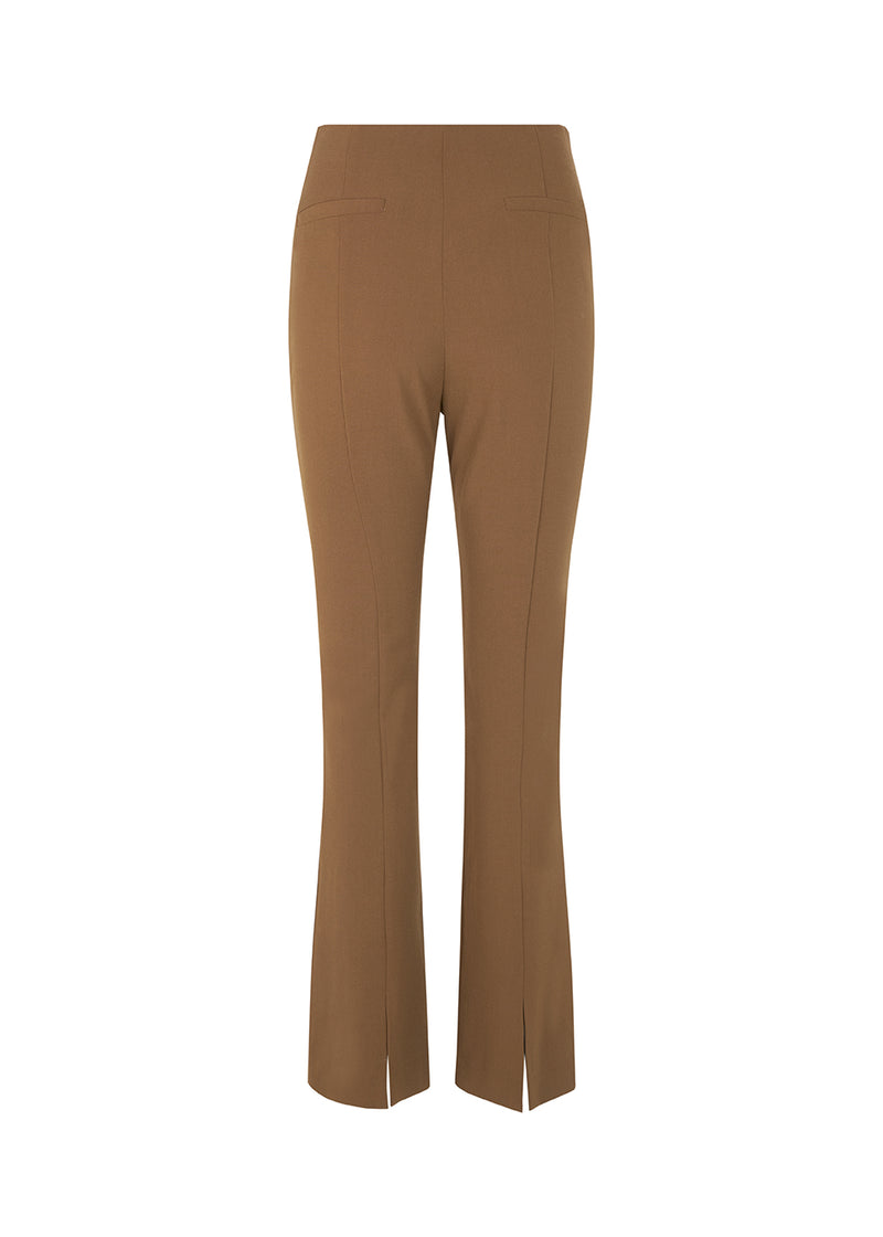 Pants in dark beige in a slim silhouette with hidden closure at one side. AnkerMD slit pants have decorative paspel back pockets, sewn-in creases, and slits at hems.