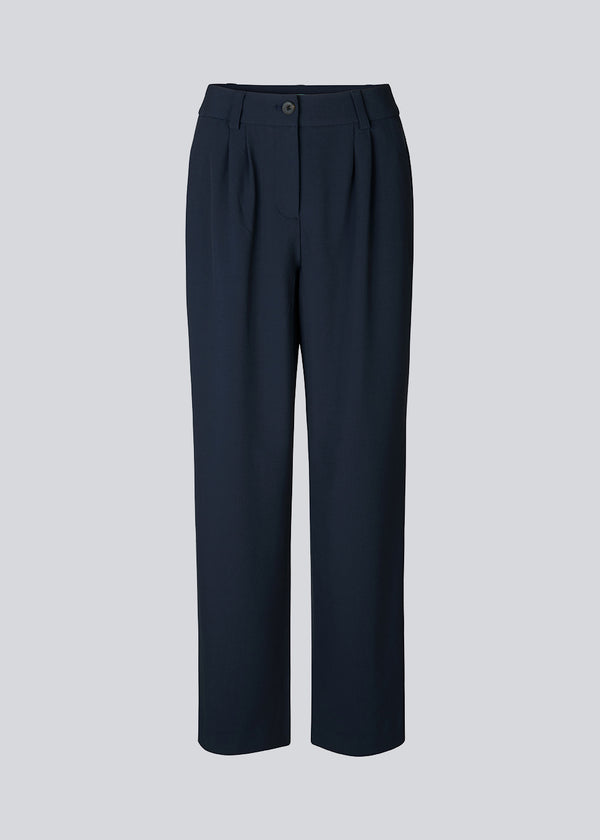 Pants in navy blue in a relaxed fit. AnkerMD wide pants have a regular waist with pleats in front and wide, long legs. Decorative back pockets and side pockets.  Match with: AnkerMD blazer
