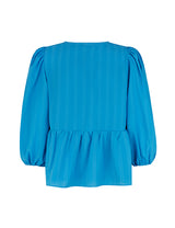 Top in blue in a loose silhouette with 3/4 length sleeves, v-shaped neckline and a cutline at the waist for extra volume on the bottom of the top.  Material: 100% Polyester