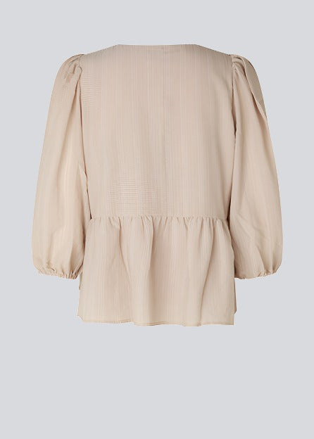 Top in beige in a loose silhouette with 3/4 length sleeves, v-shaped neckline and a cutline at the waist for ekstra volume on the bottom of the top.
