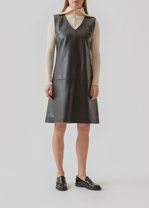 Sleeveless dress with A-shape in soft lamb leather. AspenMD dress has a v-neckline and decorative stitching. The dress cuts at the knees.