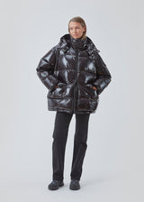 BanaMD Jacket in black is a puffer in a shiny material with natural down filling. The jacket has two padded pockets in front and with a removable hood.