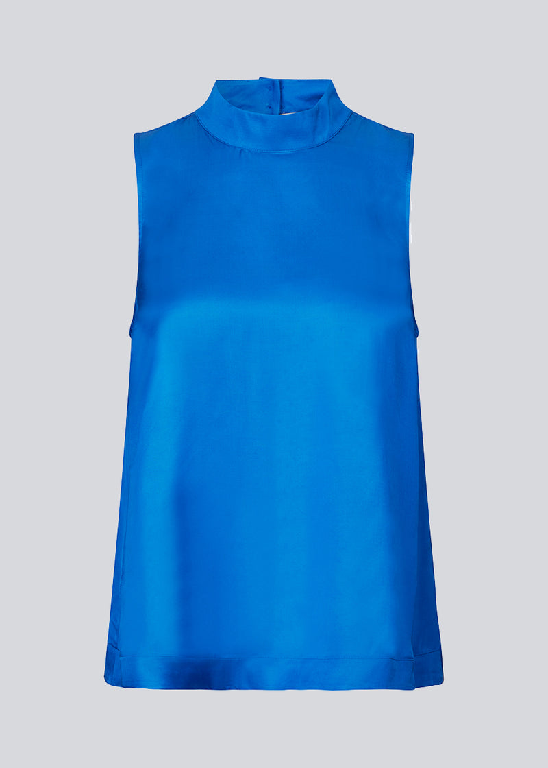 Sleeveless top in blue with a loose fit with a high neck and a small opening with button closure at the back. BeateMD top is crafted from a more resposible, softly draping satin.