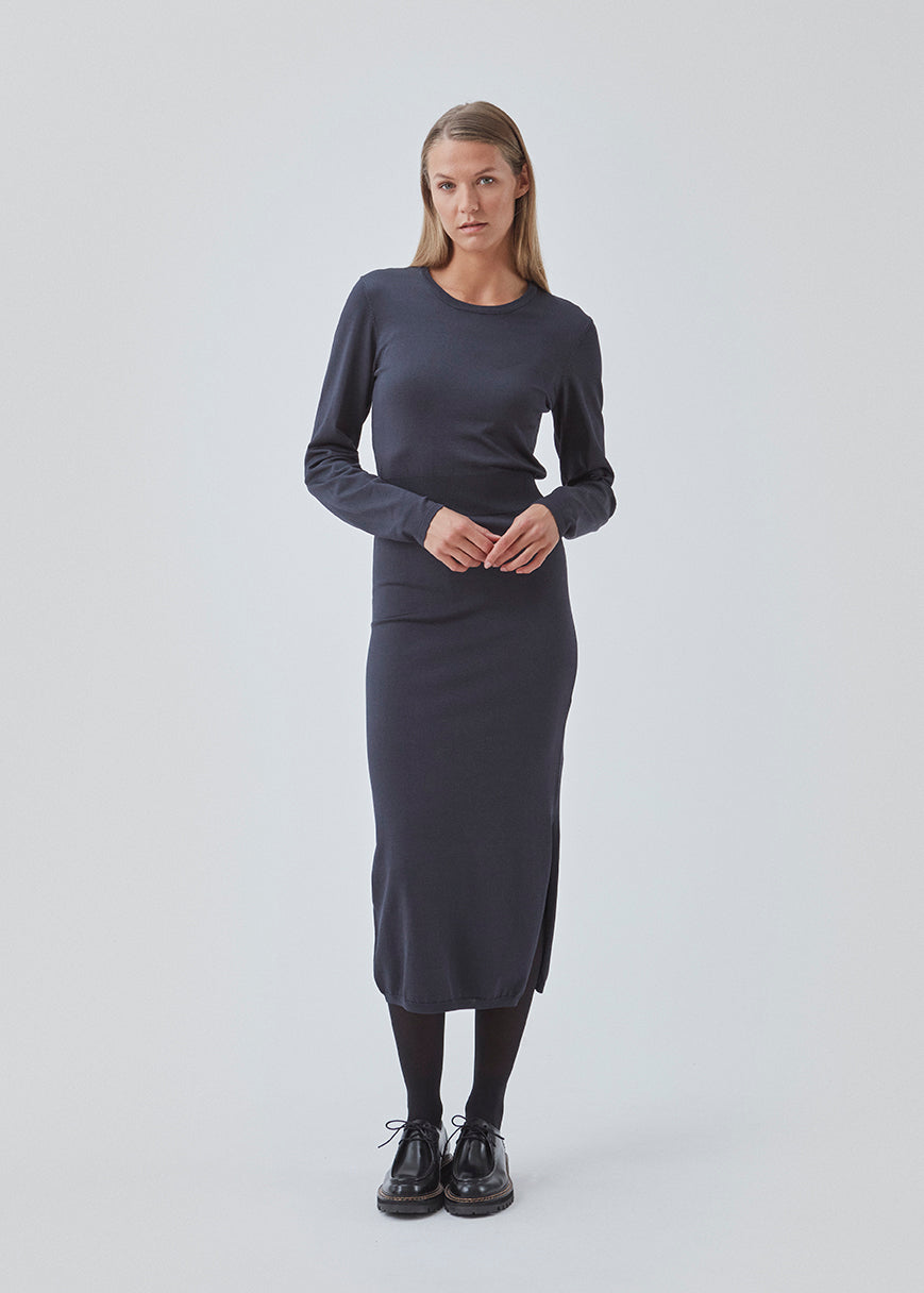 Midi dress in a knitted material with a slim fit. BilgeMD dress has a round neckline, long sleeves, rib-knit detail at the waist, and a slit at one side.