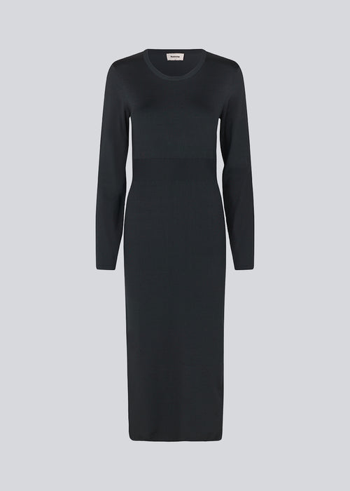 Midi dress in a knitted material with a slim fit. BilgeMD dress has a round neckline, long sleeves, rib-knit detail at the waist, and a slit at one side.