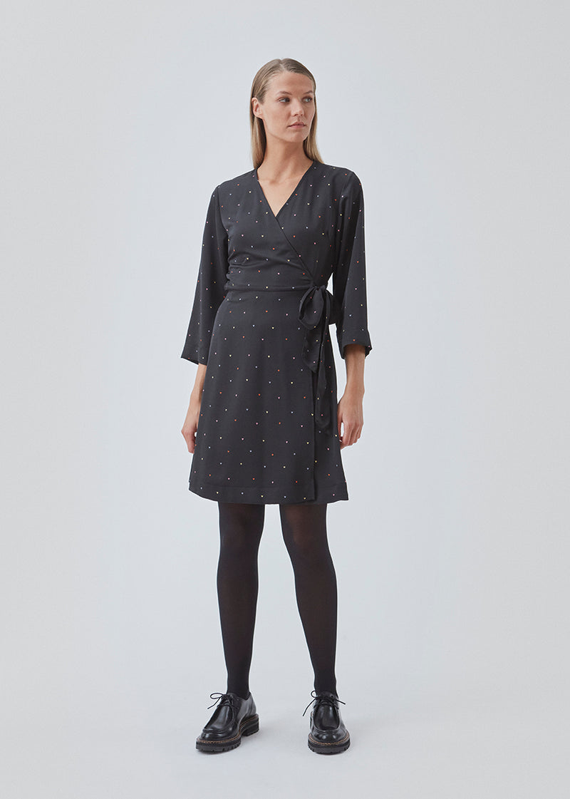 Short dress with drap around detail in front. BixMD print wrap dress has wide 3/4 sleeves, a v neckline and a tie detail in the waist