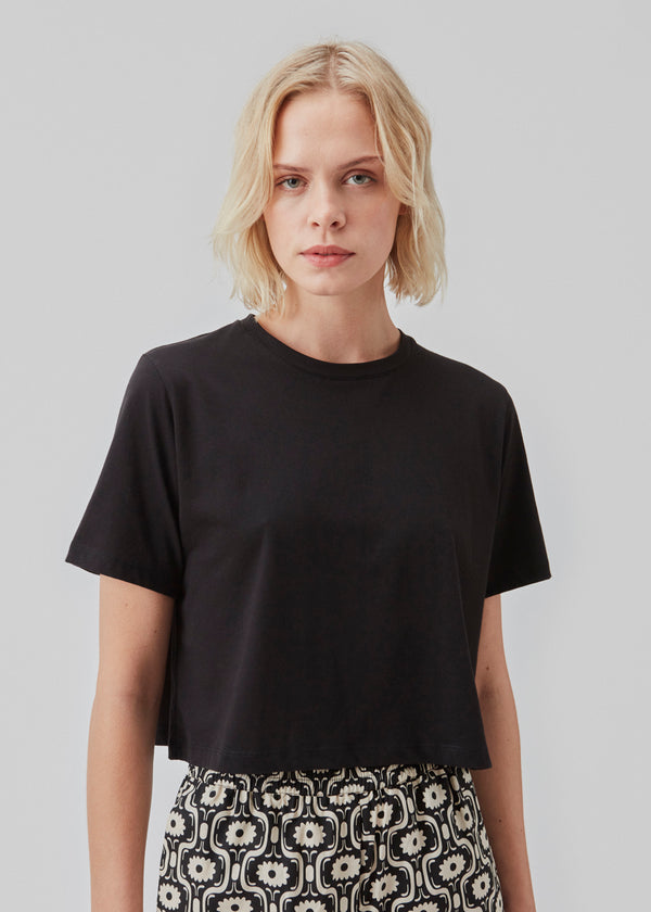 Cropped t-shirt in black with round neck and relaxed fit. CadakMD crop t-shirt is cut from soft organic cotton. The model is 177 cm and wears a size S/36.