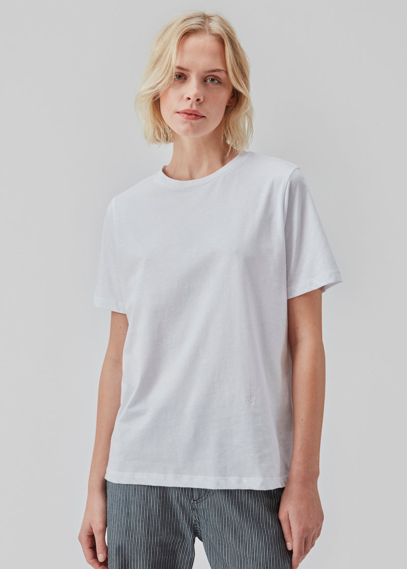 Soft t-shirt with round neck and short sleeves in white. A relaxed fit and a small embroidered logo in front. CadakMD t-shirt is made from organic cotton. The model is 177 cm and wears a size S/36.   Material: 100% Organic Cotton
