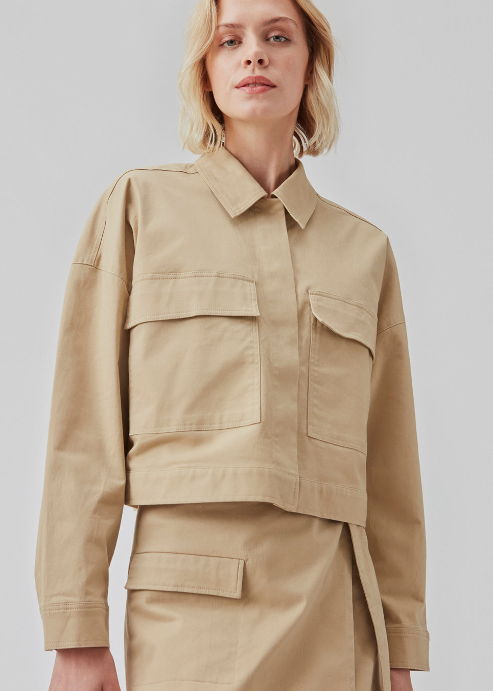 Short jacket in a woven cotton twill with a boxy fit. CalaMD jacket is detailed with collar, hidden closure in front, long sleeves, and two big patch pockets in front. The model is 177 cm and wears a size S/36.  Shop matching skirt: CalaMD skirt, or pants: CalaMD pants