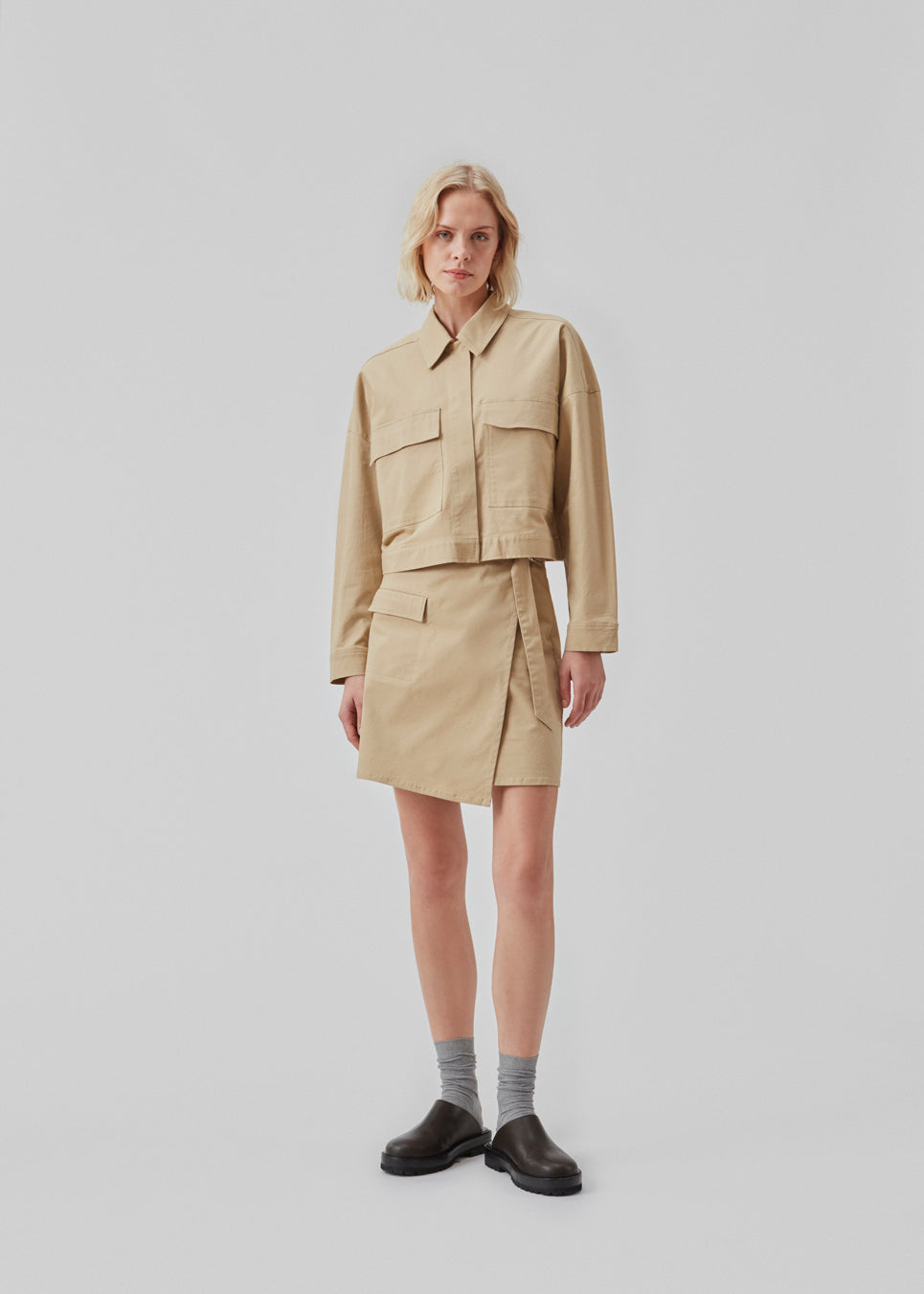 Short jacket in a woven cotton twill with a boxy fit. CalaMD jacket is detailed with collar, hidden closure in front, long sleeves, and two big patch pockets in front. The model is 177 cm and wears a size S/36.  Shop matching skirt: CalaMD skirt, or pants: CalaMD pants