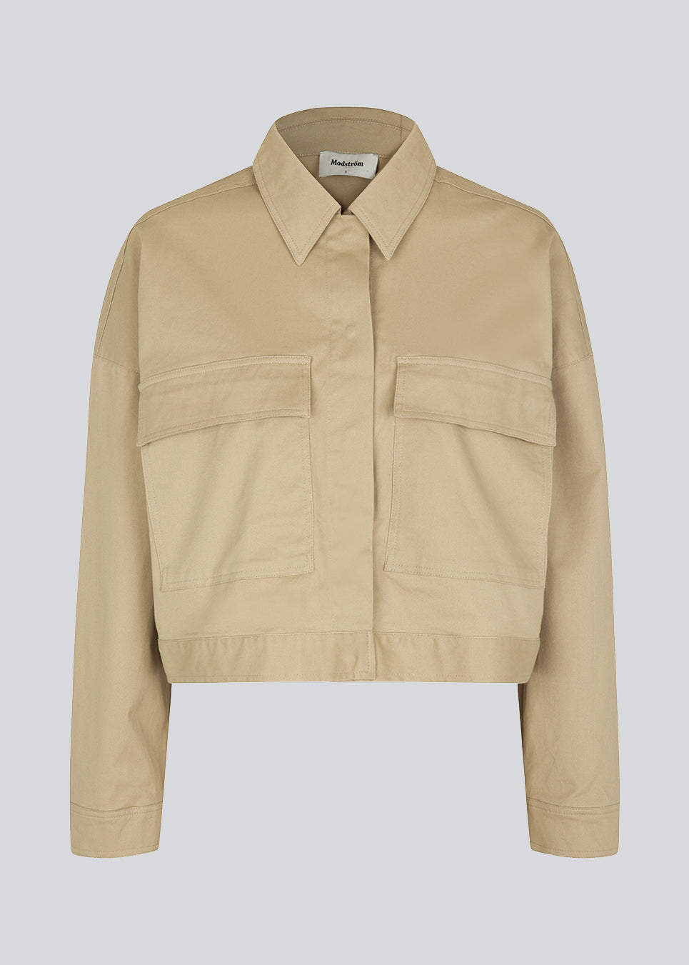 Short jacket in a woven cotton twill with a boxy fit. CalaMD jacket is detailed with collar, hidden closure in front, long sleeves, and two big patch pockets in front. The model is 177 cm and wears a size S/36.  Shop matching skirt: CalaMD skirt, or pants: CalaMD pants
