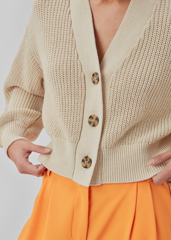 Heavy knitted cotton cardigan with a v-neckline, three large buttons, and ribbed trimmings. CalloMD cardigan is designed with a slightly cropped length.