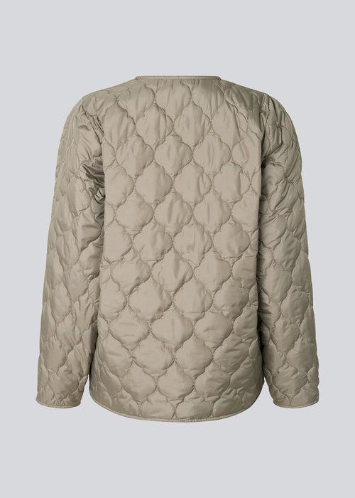 Lightly padded jacket in beige made from recycled nylon with quilted seams. CappelMD jacket has a relaxed shape detailed with a v-neck, long sleeves, and push buttons in front.