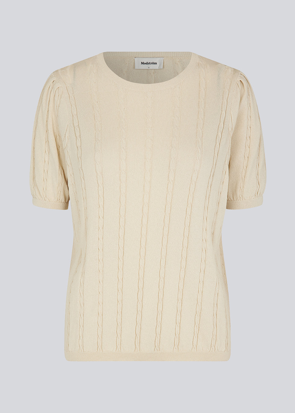 Short sleeved jumper in beige in cable knit with a round neck and puff sleeves. CarltonMD o-neck has a slim and stretchy shape. Shop the matching skirt: CarltonMD skirt. The model is 177 cm and wears a size S/36.
