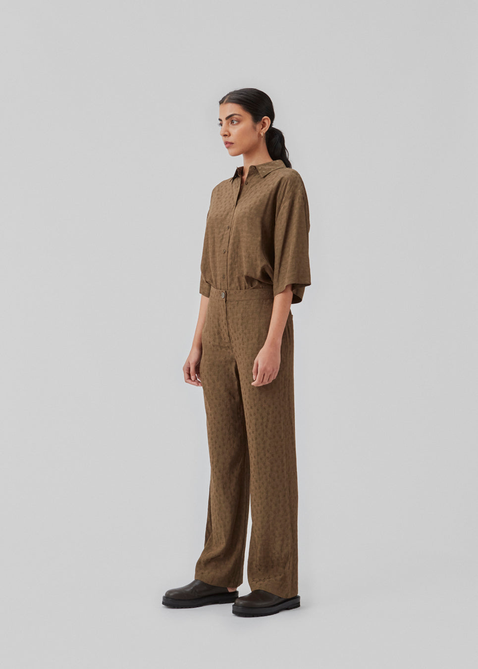 Wide-legged pants in the color Dark Forest in a patterned satin. CarmelMD pants have a medium waist with zip-fly, button closure, and elastic in the back for extra comfort. The model is 177 cm and wears a size S/36.  Shop matching shirt: CarmelMD shirt.