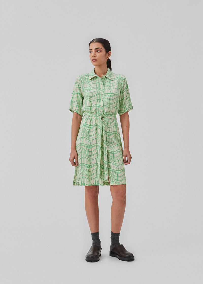 Shirt dress with a relaxed fit and short length. CarsenMD print dress has short wide sleeves, button closure in front, and tiebelt at the waist.  The model is 174 cm and wears a size S/36. 