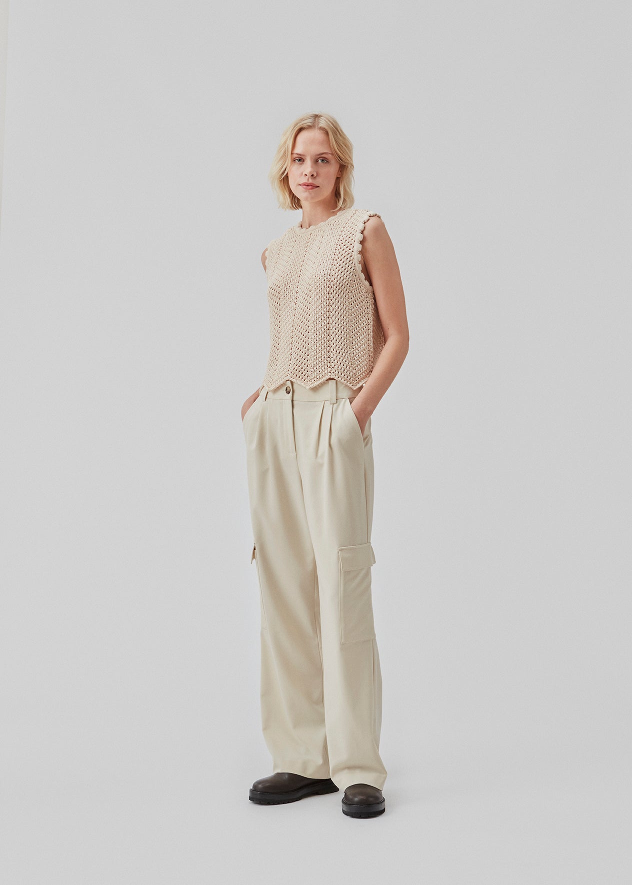 Crochet top in beige without sleeves in organic cotton. CaryMD top has detailed trimmings and a deep v-neckline in the back. The model is 177 cm and wears a size S/36.