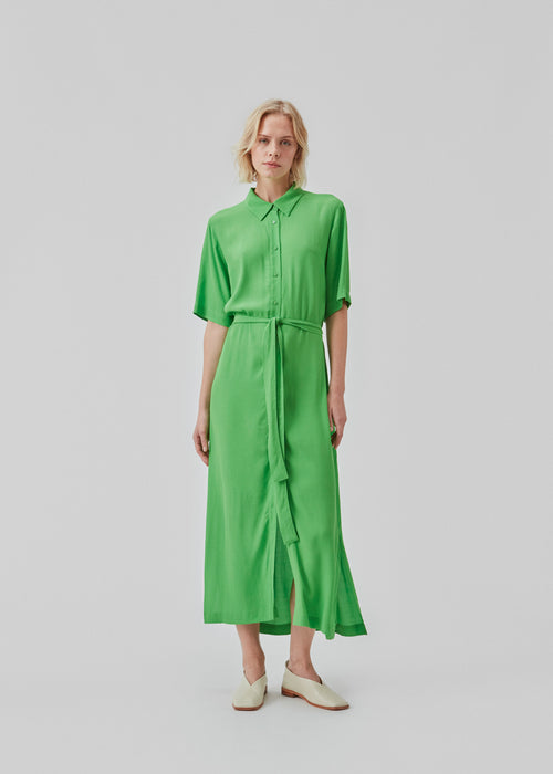 Long shirt dress with short wide sleeves, collar, buttons in front, and tiebelt at the waist. CashMD long dress is crafted from an EcoVero viscose. The model is 174 cm and wears a size S/36.