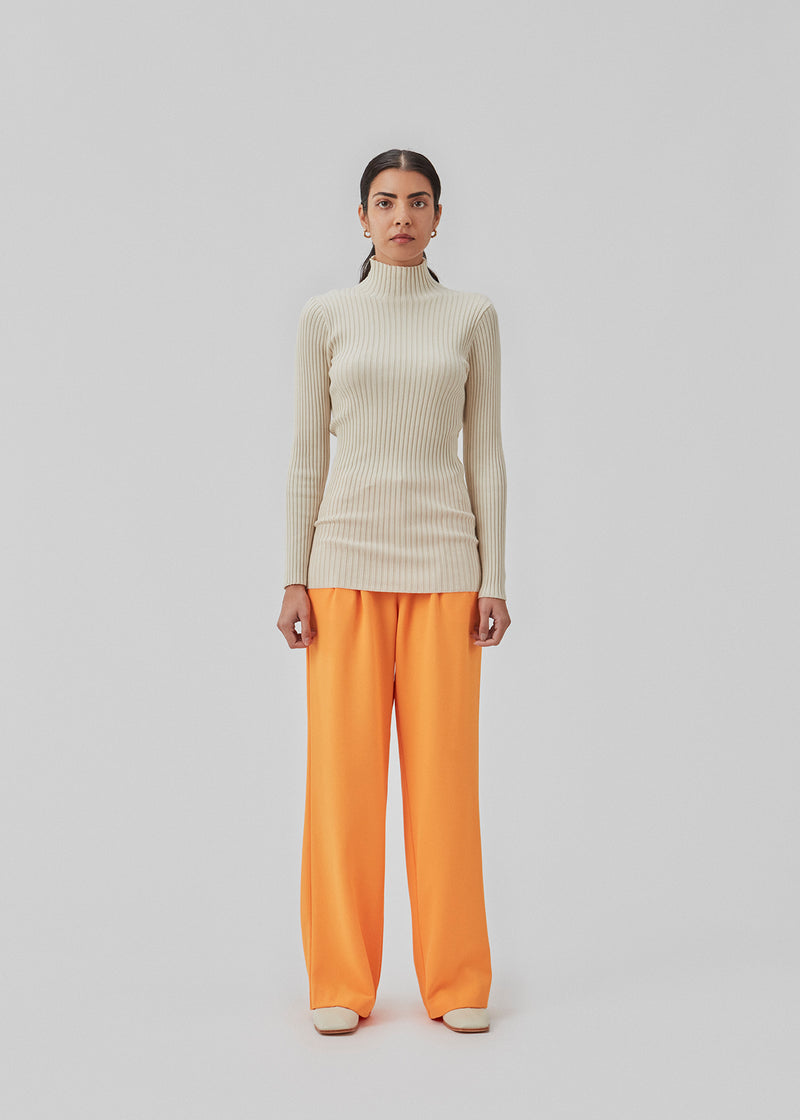 Slim fitted long-sleeved top in the color Summer Sand in a stretchy rib knit with a high neck. Made from more responsible materials.