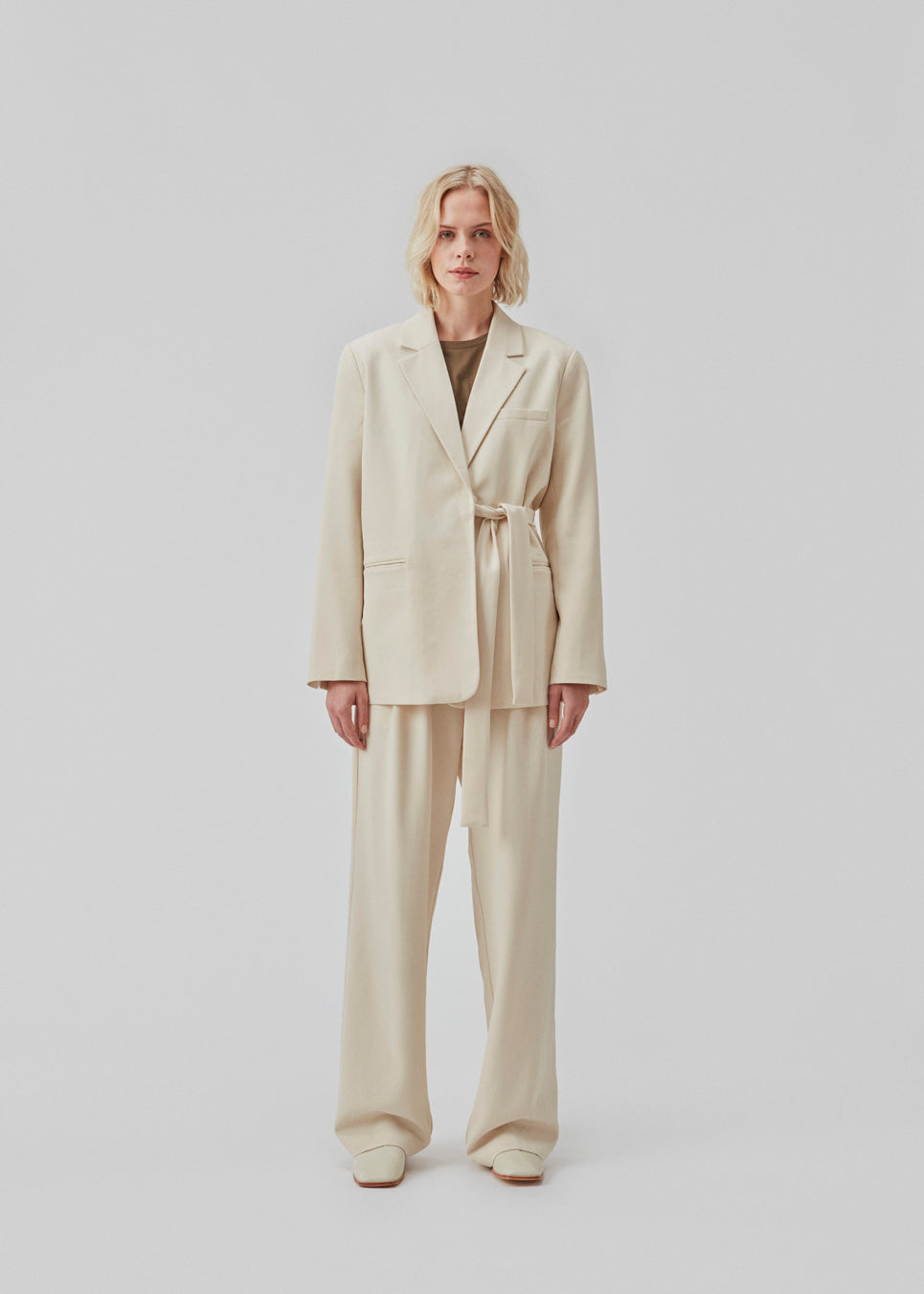 CayaMD blazer is designed for a relaxed fit with classic details with a twist from the tie-belt at the waist. Made from recycled materials. The model is 177 cm and wears a size S/36.  Style with the matching pants: CayaMD pants.