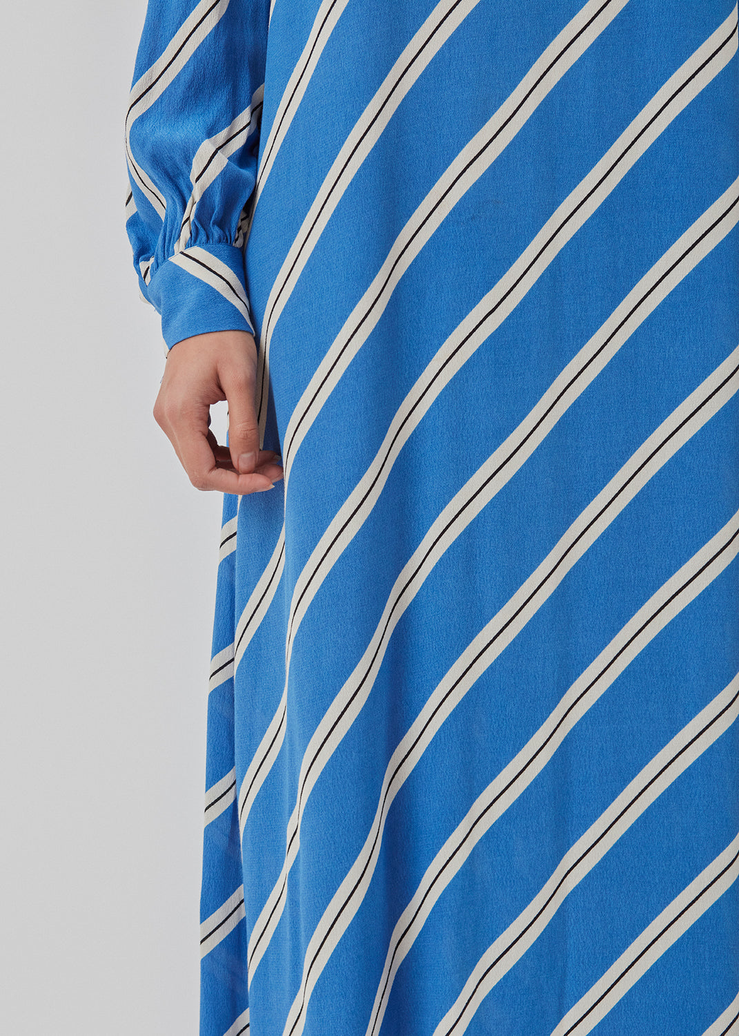 Relaxed long shirt dress with collar, button placket, and long puff sleeves. CenniMD print dress is cut from an EcoVero viscose with diagonal stripes.