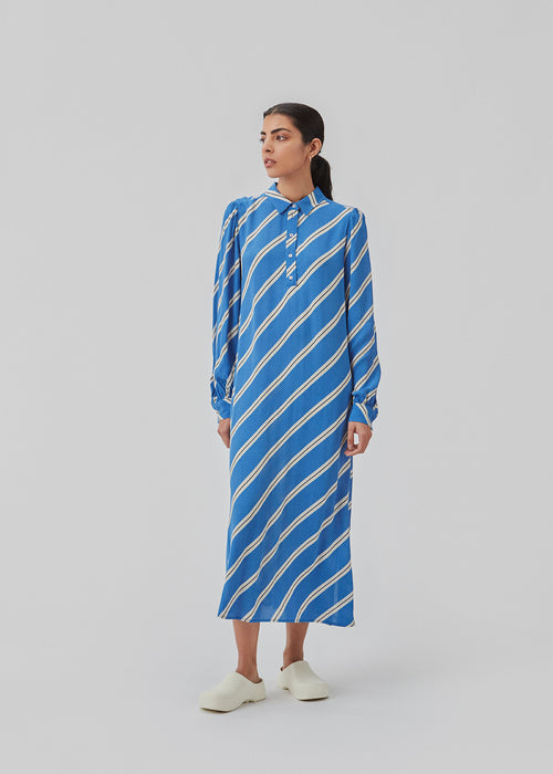 Relaxed long shirt dress with collar, button placket, and long puff sleeves. CenniMD print dress is cut from an EcoVero viscose with diagonal stripes.