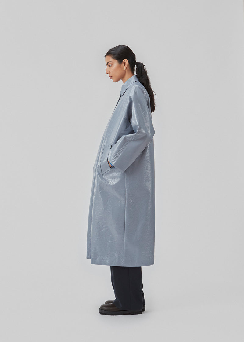 Oversized coat in a shiny material. CharlesMD coat features a collar, push buttons, and long wide sleeves.
